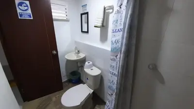a bathroom with a white toilet and a sink at HOSTAL EL ALTISIMO in Cartagena de Indias