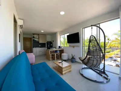 a living room with a blue couch and a swing at NAHIR apartamento de playa en condominio Palmar del viento in San Bernardo del Viento