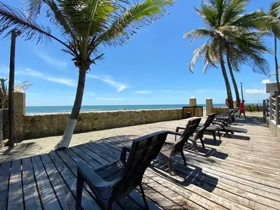 a row of chairs sitting on a boardwalk next to the beach at NAHIR apartamento de playa en condominio Palmar del viento in San Bernardo del Viento