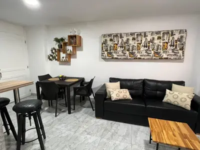 a living room with a black couch and a table at Apartamento -Laguito-Bocagrande in Cartagena de Indias