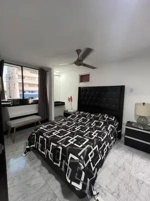 a bedroom with a black and white bed and a piano at Apartamento -Laguito-Bocagrande in Cartagena de Indias