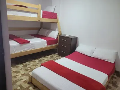 a bedroom with two bunk beds with red and white sheets at Apartahotel Los Ángeles in Cartagena de Indias
