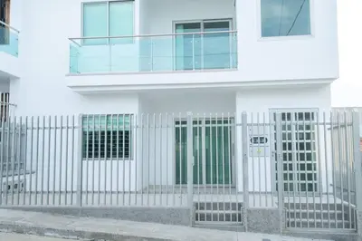 a white building with a gate in front of it at Makadamia Aptos in Sincelejo