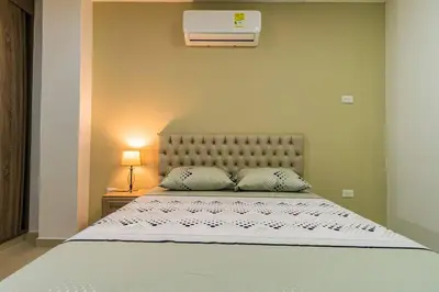 a bedroom with a large bed with a white bedspread at Makadamia Aptos in Sincelejo