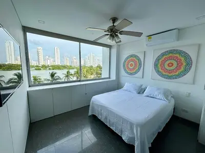a bedroom with a bed and a large window at Apartamento en Laguito Ed. Cristoforo 303 ICDI in Cartagena de Indias