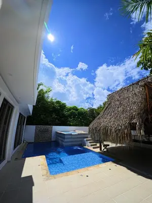 a resort with a swimming pool and a thatch roof at CountrySide Stay Melina in San Mateo
