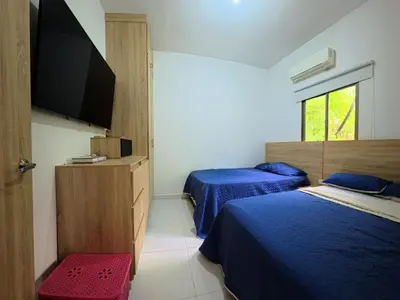 a bedroom with two beds and a flat screen tv at CountrySide Stay Melina in San Mateo