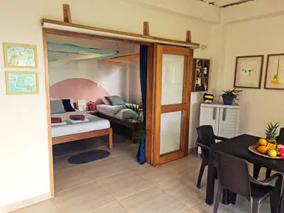 a living room with a bed and a dining room at Deluxe Family Suite - In front of the sea in Moñitos