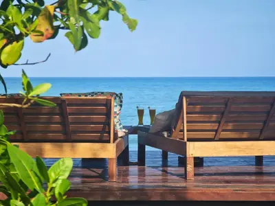 two chairs on a deck with the ocean in the background at Deluxe Family Suite - In front of the sea in Moñitos