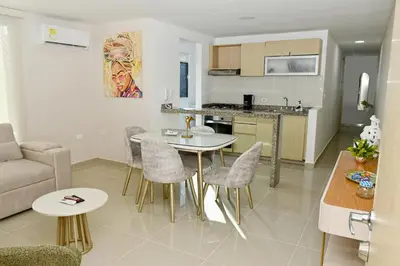 a kitchen and a living room with a table and chairs at Excelente ubicación, cómodo apartamento in Barranquilla