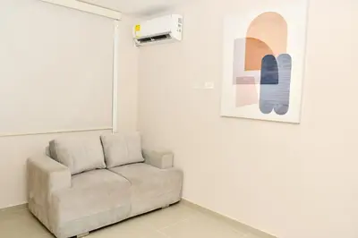 aige couch in a room with a picture on the wall at Excelente ubicación, cómodo apartamento in Barranquilla