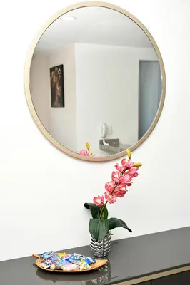 a vase of flowers on a counter with a mirror at Apartamento familiar con excelente ubicación Barranquilla in Barranquilla