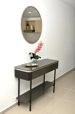 a table with a mirror and a vase with flowers on it at Apartamento familiar con excelente ubicación Barranquilla in Barranquilla