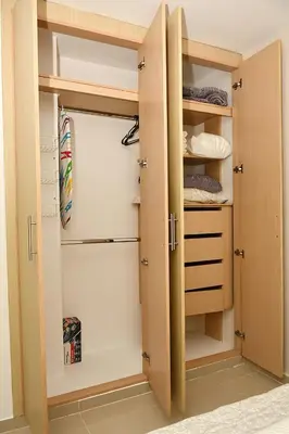 a walk in closet with wooden doors and shelves at Apartamento familiar con excelente ubicación Barranquilla in Barranquilla