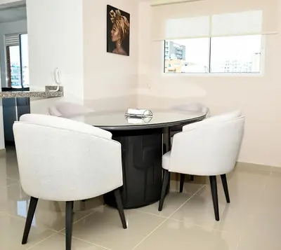 a dining room with a table and two white chairs at Apartamento familiar con excelente ubicación Barranquilla in Barranquilla