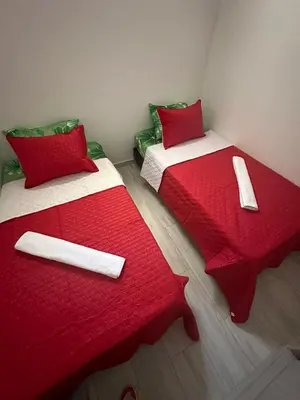 two beds with red and white covers in a room at Campiña Stay Apartamento Amoblado in Cartagena de Indias