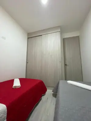 a bedroom with two beds and a red blanket at Campiña Stay Apartamento Amoblado in Cartagena de Indias