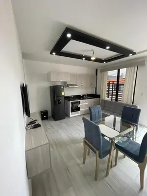 a living room with a table and chairs and a kitchen at Campiña Stay Apartamento Amoblado in Cartagena de Indias