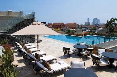a patio with tables and chairs and a pool at Bastión Luxury Hotel in Cartagena de Indias
