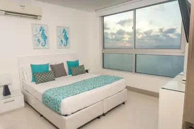 a bedroom with a bed and a large window at Apartamento 3404 Palmetto Beach Frente a la playa in Cartagena de Indias