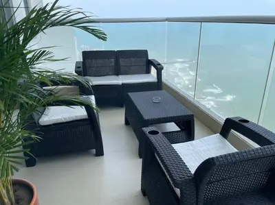 a balcony with two chairs and a table and chairs at Apartamento 3404 Palmetto Beach Frente a la playa in Cartagena de Indias