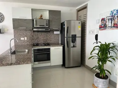 a kitchen with a stainless steel refrigerator and a microwave at Apartamento 3404 Palmetto Beach Frente a la playa in Cartagena de Indias
