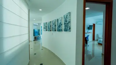 a hallway with white walls and a sliding glass door at Penthouse Marea Con Jacuzzi Privada Vista Mar in Cartagena de Indias