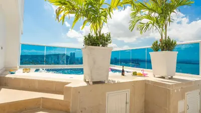 a bathroom with three potted plants and a swimming pool at Penthouse Marea Con Jacuzzi Privada Vista Mar in Cartagena de Indias