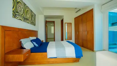 a bedroom with a bed with a blue and white comforter at Penthouse Marea Con Jacuzzi Privada Vista Mar in Cartagena de Indias