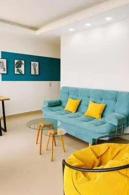 a living room with a blue couch and yellow pillows at Lindo apto vista al mar,central y piscina rooftop in Cartagena de Indias