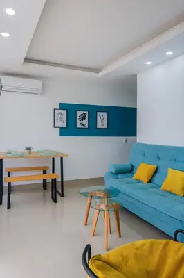 a living room with a blue couch and a table at Lindo apto vista al mar,central y piscina rooftop in Cartagena de Indias