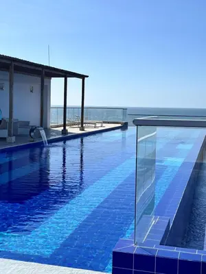 a swimming pool with the ocean in the background at Confortable Apartamento Ocean Drive 711 -estancia mínima 2 noches- in Cartagena de Indias
