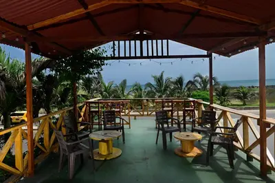 a patio with tables and chairs and the ocean at Casa Hotel Terraza del Cabrero in Cartagena de Indias