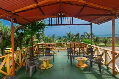 a patio with tables and chairs and the ocean at Casa Hotel Terraza del Cabrero in Cartagena de Indias