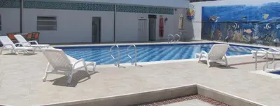 a swimming pool with white chairs and a swimming pool at Hotel Mar del Plata in Cartagena de Indias