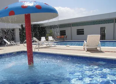 a pool with a red and blue umbrella in the water at Hotel Mar del Plata in Cartagena de Indias