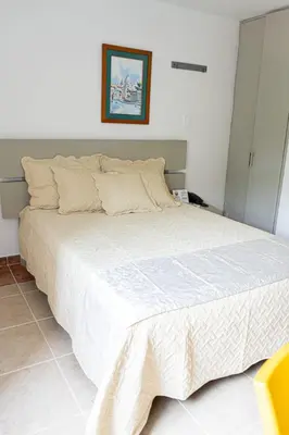 a bedroom with a large bed with a white comforter at Hotel Mar del Plata in Cartagena de Indias