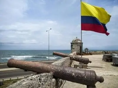 a flag and a cannon next to the ocean at MoraRoom in Cartagena de Indias
