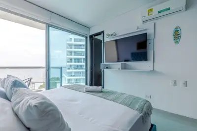 a white bed in a room with a large window at Espectacular apartamento en Cartagena Seaway935 - Morros in Cartagena de Indias