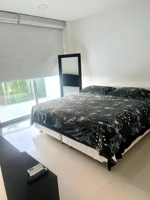 a bedroom with a bed with a black comforter and a window at MORROS EPIC Un refugio frente al mar in Cartagena de Indias