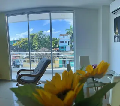 a room with a chair and a table and a yellow flower at Apartamento 202 in Cartagena de Indias