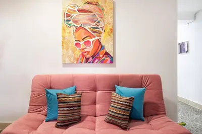 a pink couch with pillows and a painting on the wall at Apartamento Central Frente al Mar Cartagena in Cartagena de Indias