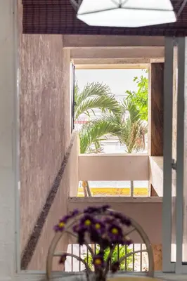 a vase of flowers on a table in front of a window at Apartamento Central Frente al Mar Cartagena in Cartagena de Indias