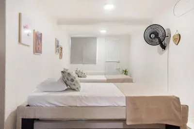two beds in a room with white walls at Apartamento Central Frente al Mar Cartagena in Cartagena de Indias