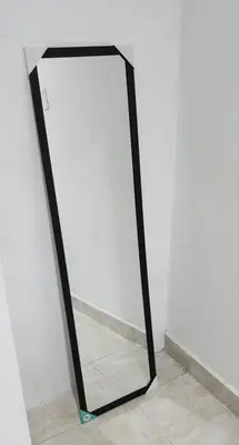 a mirror with a black frame sitting on a floor at Lindo Apartamento cerca al Estadio Metropolitano in Barranquilla