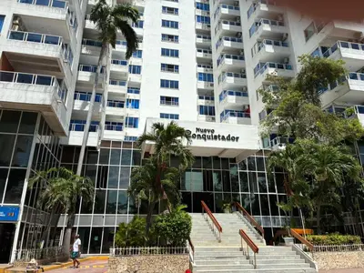 a large building with palm trees in front of it at Hermoso apartamento con vista al mar in Cartagena de Indias