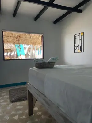 a bed in a room with a window at Palenque Beach House in San Onofre