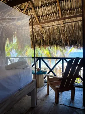 a bed and a chair in a room with a view of the ocean at Palenque Beach House in San Onofre