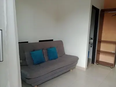 a couch with two blue pillows in a room at Apartahotel Eden Coveñas in Coveñas