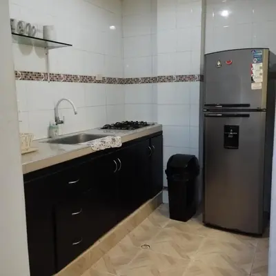 a kitchen with a stainless steel refrigerator and a sink at Apartahotel Eden Coveñas in Coveñas